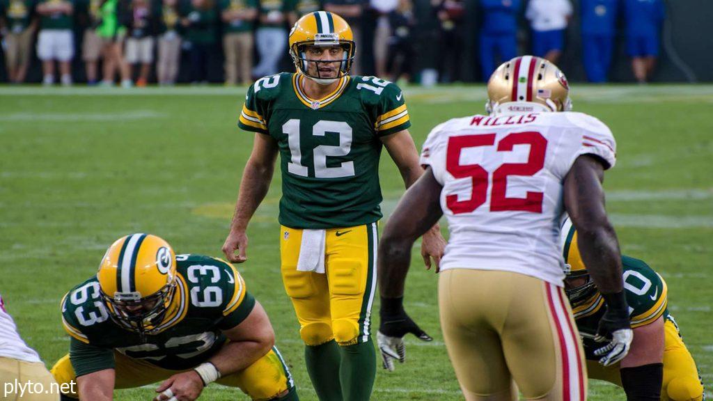 Zach Wilson discussing strategy with Aaron Rodgers during a practice session.