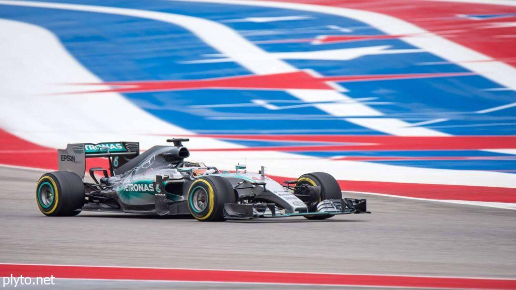 Vibrant crowd waving flags and cheering at the Mexican Grand Prix, showcasing the excitement of Formula 1 racing.