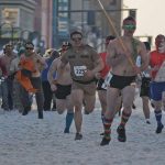 Runners in spooky costumes participate in a Halloween 5K race event.