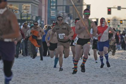 Runners in spooky costumes participate in a Halloween 5K race event.