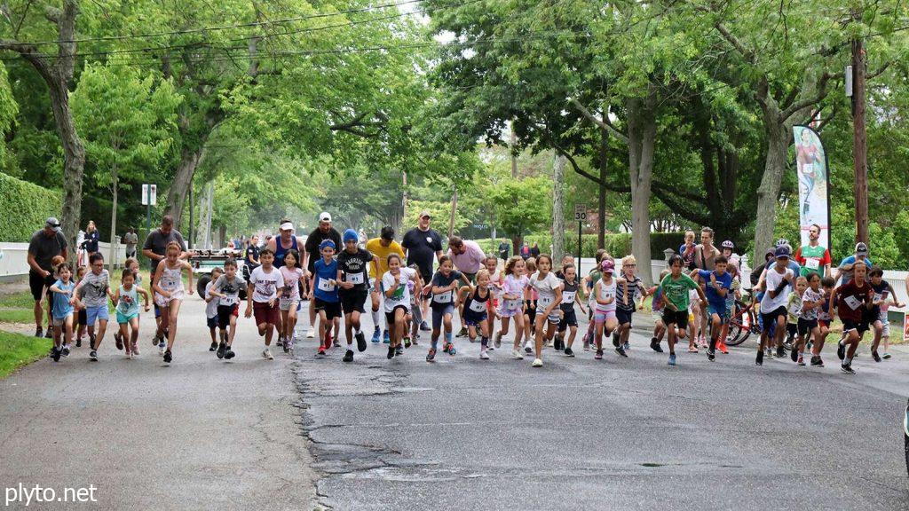 Participants line up at the Halloween 5K race starting line, dressed as witches and monsters.