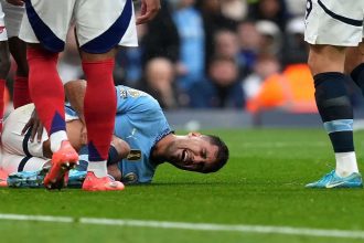 Manchester City manager Pep Guardiola discussing injury concerns at a press conference