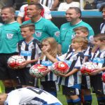 Exciting moment from the Newcastle vs. Arsenal match at St. James' Park, showcasing passionate fans cheering for their teams.