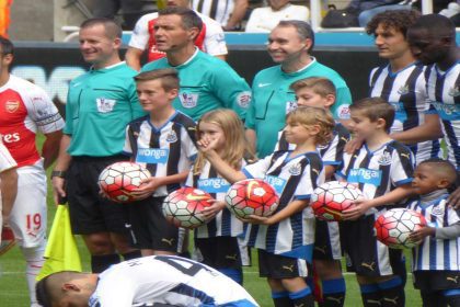 Exciting moment from the Newcastle vs. Arsenal match at St. James' Park, showcasing passionate fans cheering for their teams.